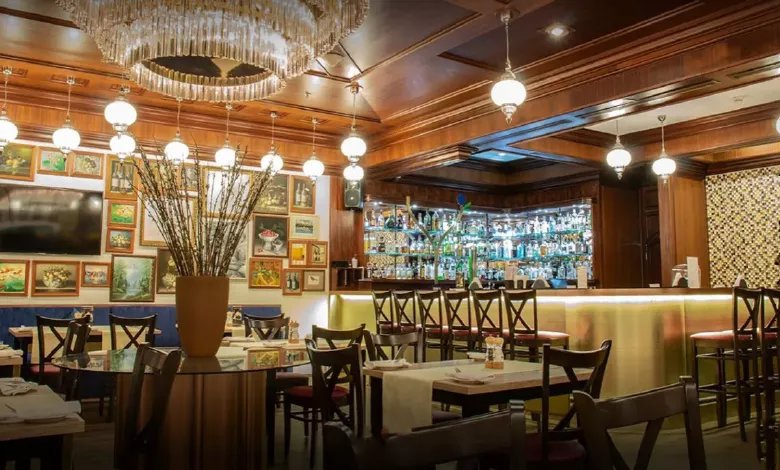 Elegant Chingari restaurant interior with chandelier lighting, framed wall art, and a well-stocked bar.