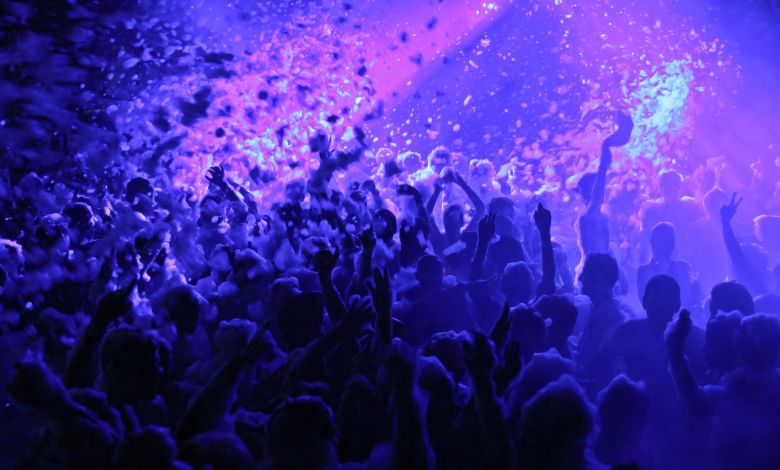 Energetic foam party with vibrant lighting in an Amsterdam nightclub filled with dancing people