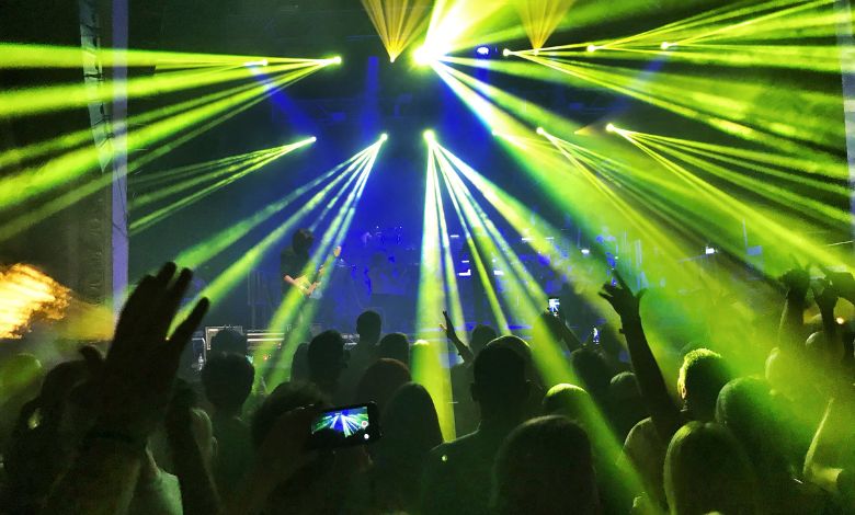 Crowd enjoying live music and laser light show in a packed nightclub