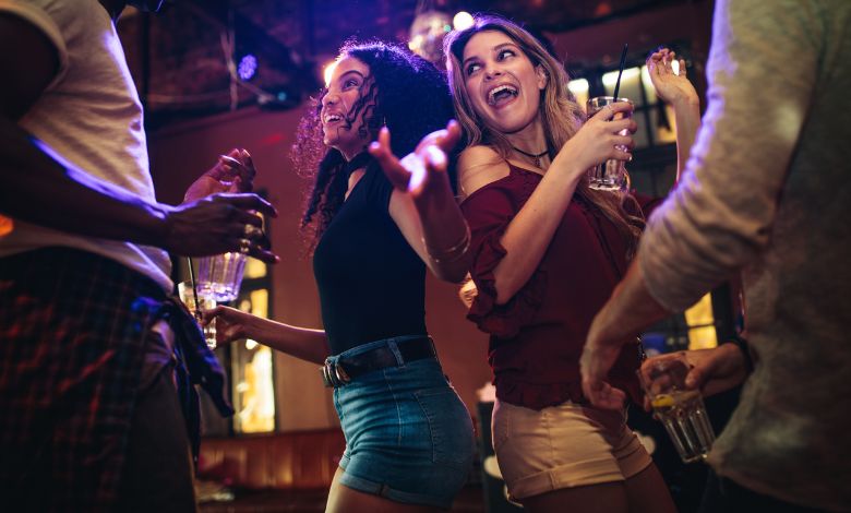 Friends dancing and enjoying drinks at a lively nightclub
