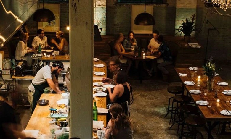 Cozy restaurant interior with diners and an open kitchen inTrue Italic