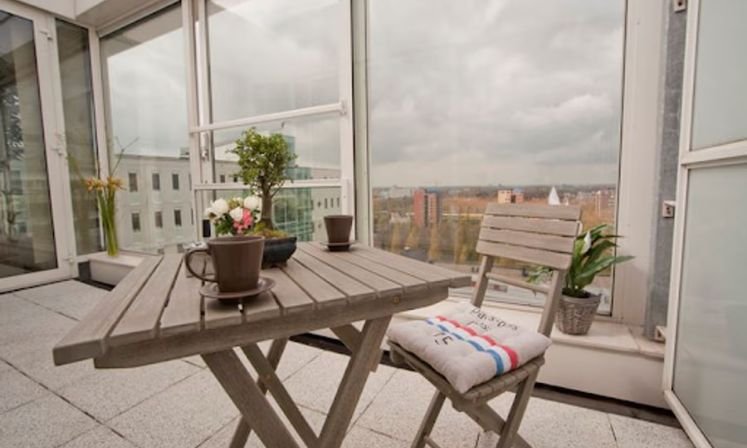 A balcony with a table and chairs at Koningin Wilhelminaplein Serviced Apartments in Amsterdam 