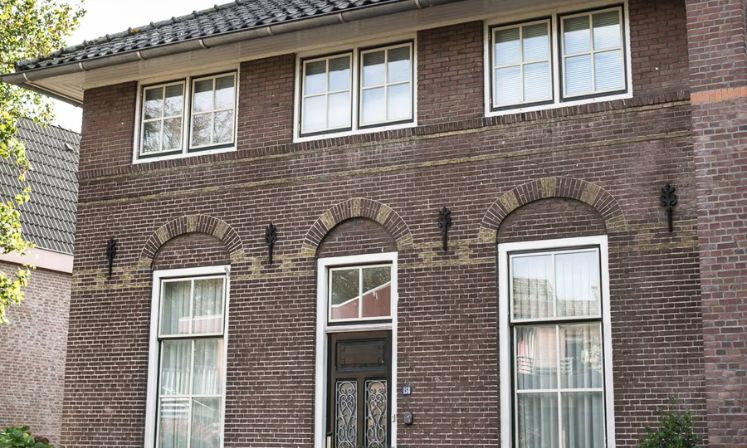 The Molenland Apartment, a brick house adorned with a black door and windows.