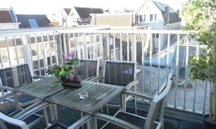 Balcony of Monnikenstraat Serviced Apartment featuring chairs and a table, ideal for large groups to enjoy the view.