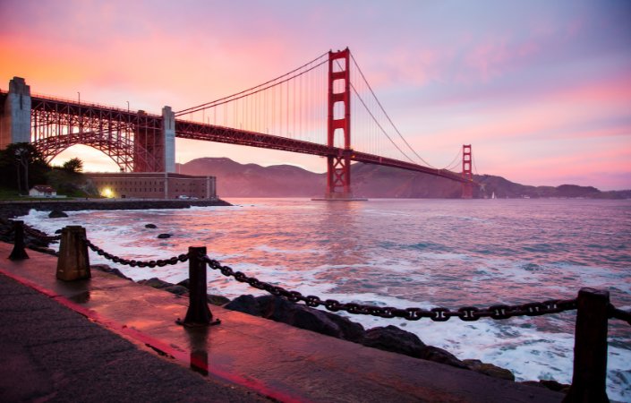 Bay Bridge with city in the background at dusk