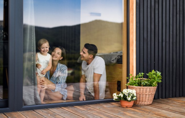 Happy family by cabin window.
