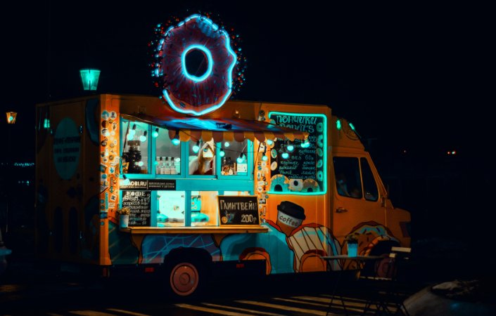 Neon-lit donut truck at night