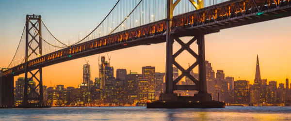 Bay Bridge San Francisco with city in the background at dusk.