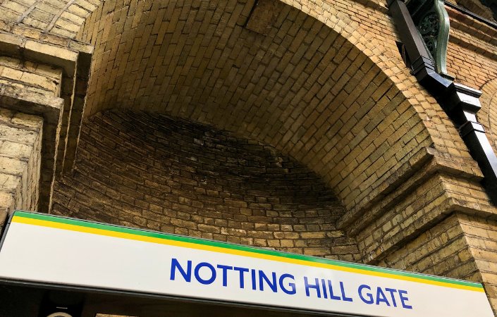 Notting Hill Gate London Underground station sign beneath historic brick arch.