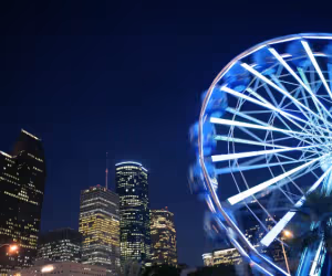 Houston skyline at night with illuminated Ferris wheel and downtown buildings