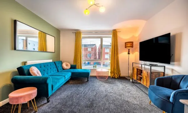Stylish living room in a serviced apartment in Manchester featuring vibrant decor and a large window
