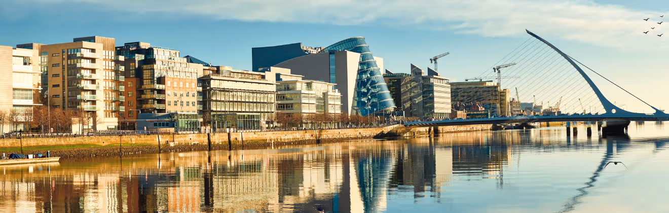 Riverside view of modern serviced apartments and the Samuel Beckett Bridge in Dublin on a clear day