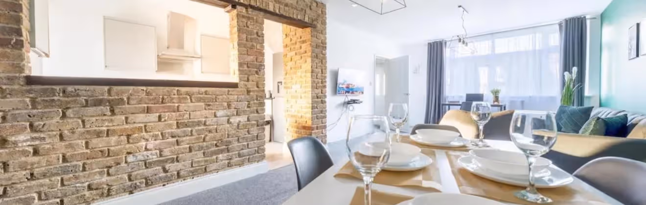 Modern apartment in Slough with an open-plan living and dining area and exposed brick walls.